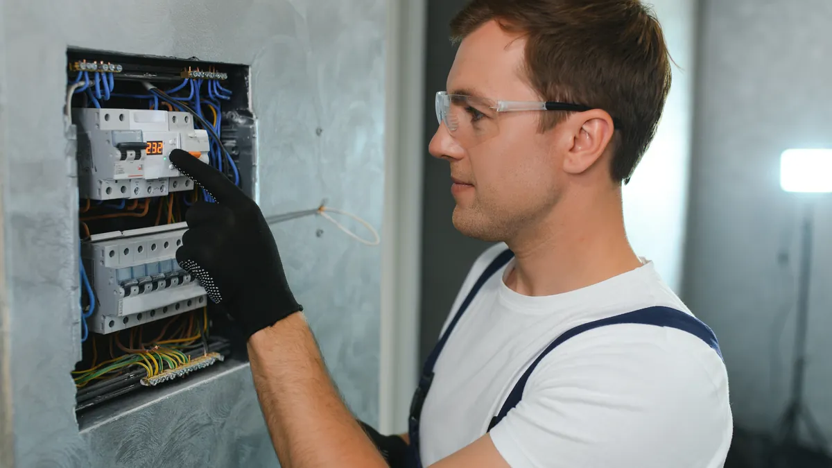 Electricista trabajando en el cuadro eléctrico para añadir las protecciones del cargador