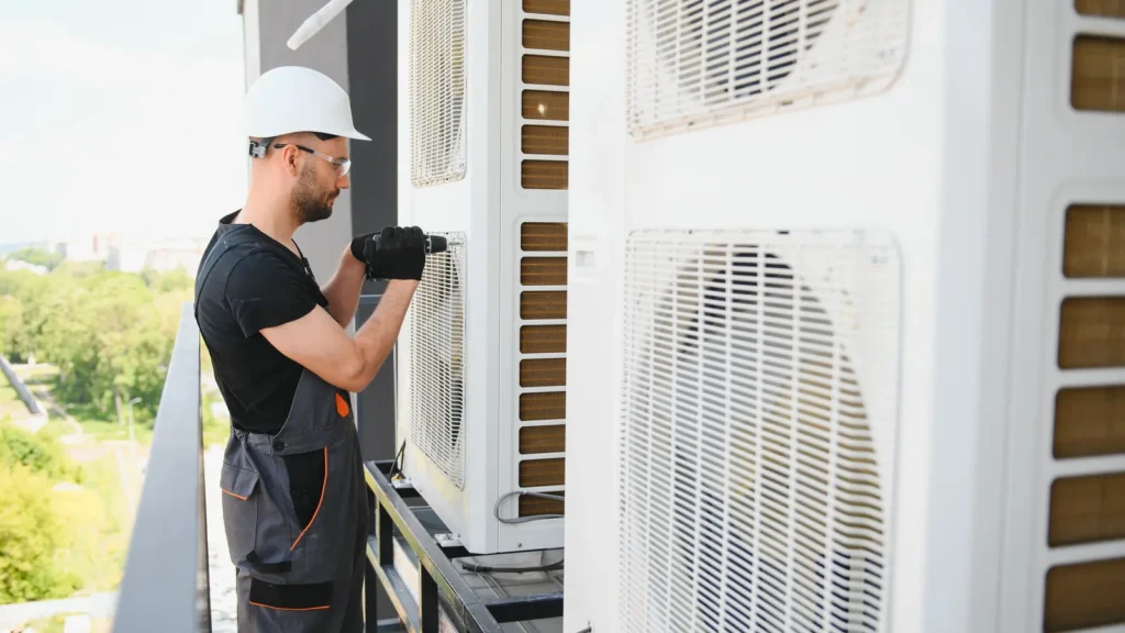 Técnico instalando la unidad exterior de un aire acondicionado en un balcón