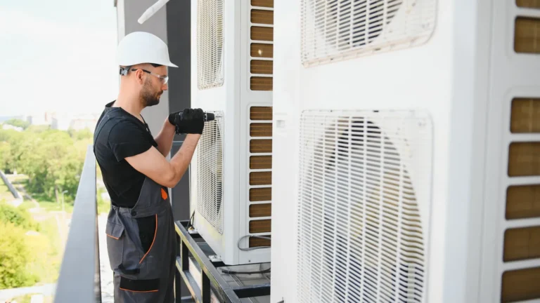 Técnico instalando la unidad exterior de un aire acondicionado en un balcón